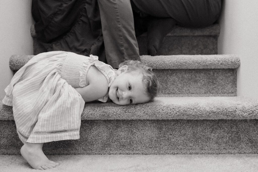 A little girl snuggled up on the stairwell during a family photo session in bremerton, wa.